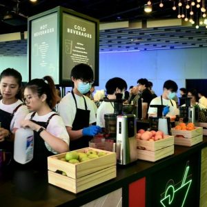 A group of workers facilitating a live juice pressing station