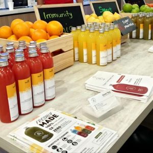 antidote juice bottles lined up on a table for a pop up event