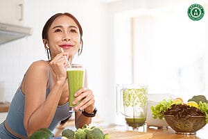 woman drinking a green smoothie