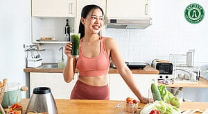 Physically fit woman drinking a vegetable smoothie