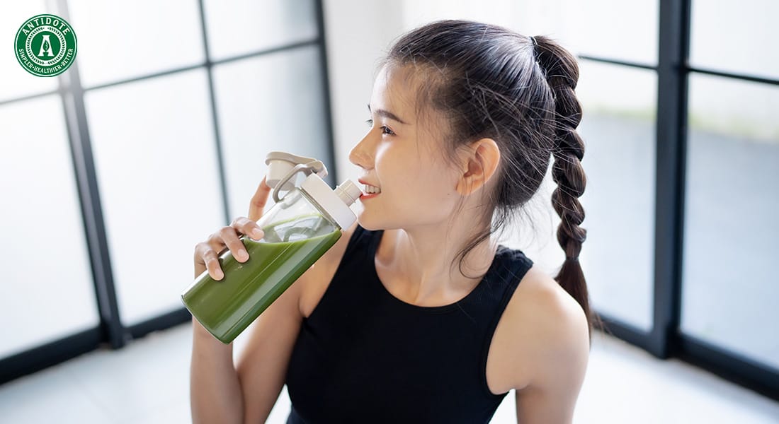 woman drinking detox juice after exercising